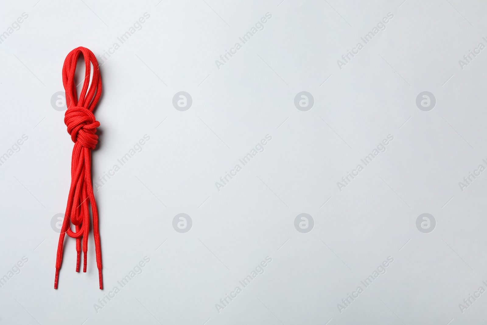 Photo of Red shoelaces on light background, top view. Space for text