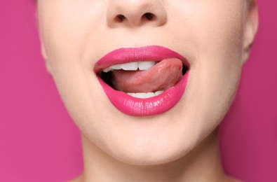 Beautiful young woman with perfect lips makeup on color background, closeup