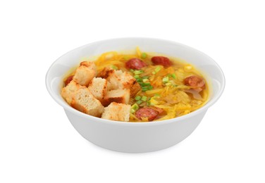 Photo of Bowl of delicious sauerkraut soup with smoked sausages, green onion and croutons isolated on white