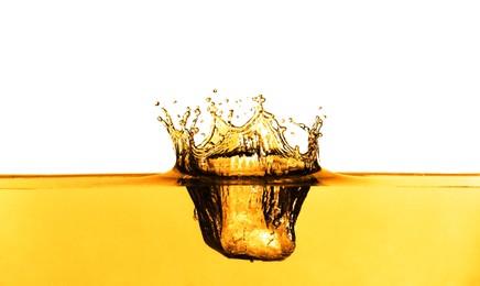 Image of Golden oily liquid splash on white background