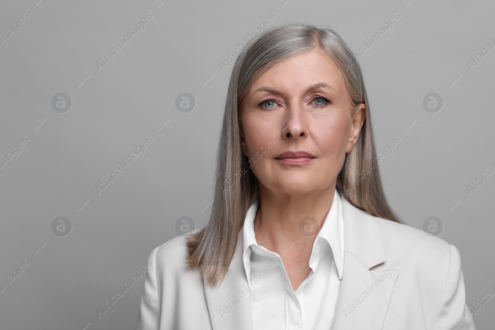 Photo of Portrait of beautiful senior woman on grey background. Space for text