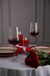 Photo of Place setting with roses and candles on white table. Romantic dinner