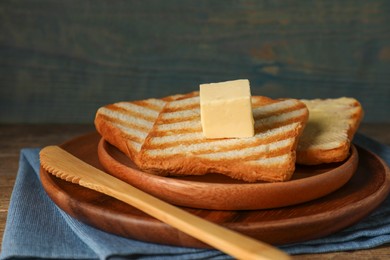 Photo of Tasty toasts with butter served on table, closeup
