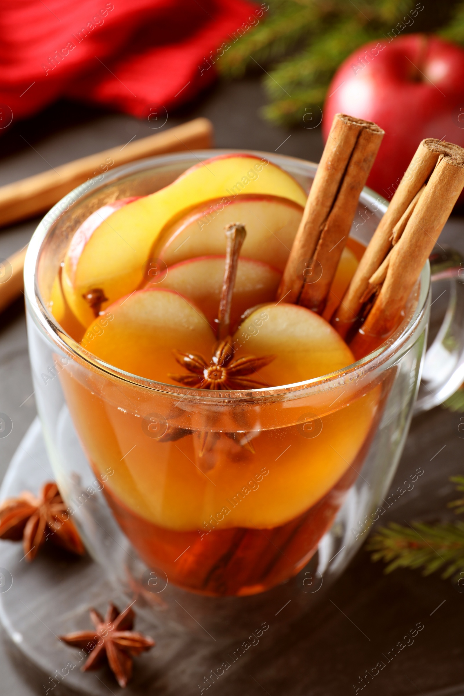 Photo of Aromatic hot mulled cider on black board, closeup