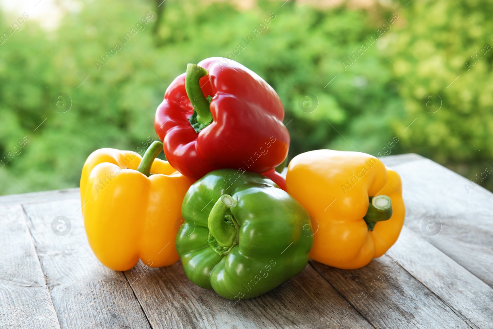 Photo of Raw ripe paprika peppers on table against blurred background