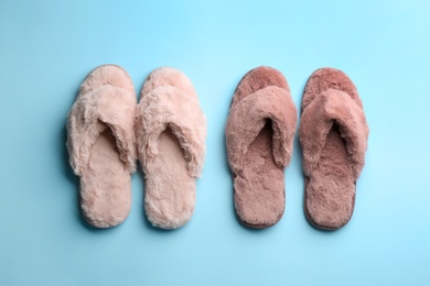 Different stylish soft slippers on light blue background, flat lay