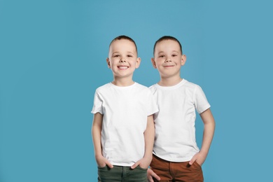 Photo of Portrait of cute twin brothers on color background