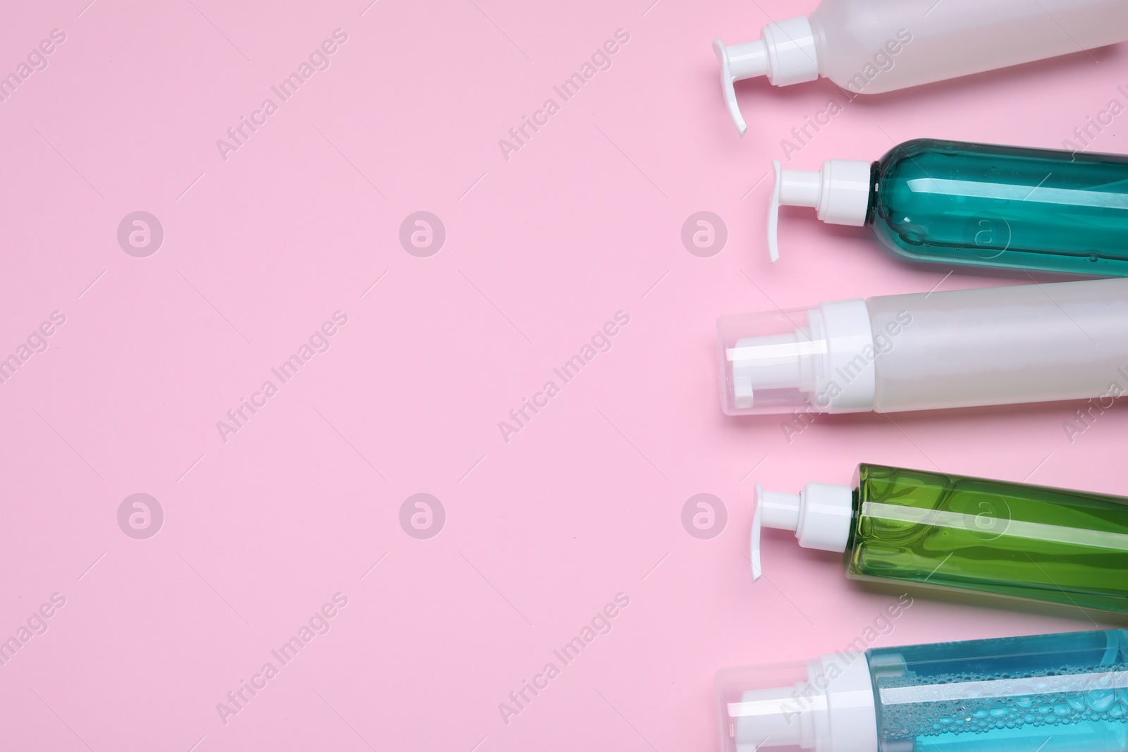 Photo of Different cleansers on pink background, flat lay with space for text. Cosmetic product