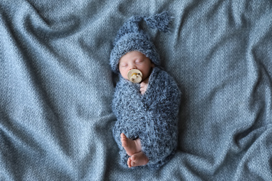 Cute newborn baby sleeping on blanket, top view