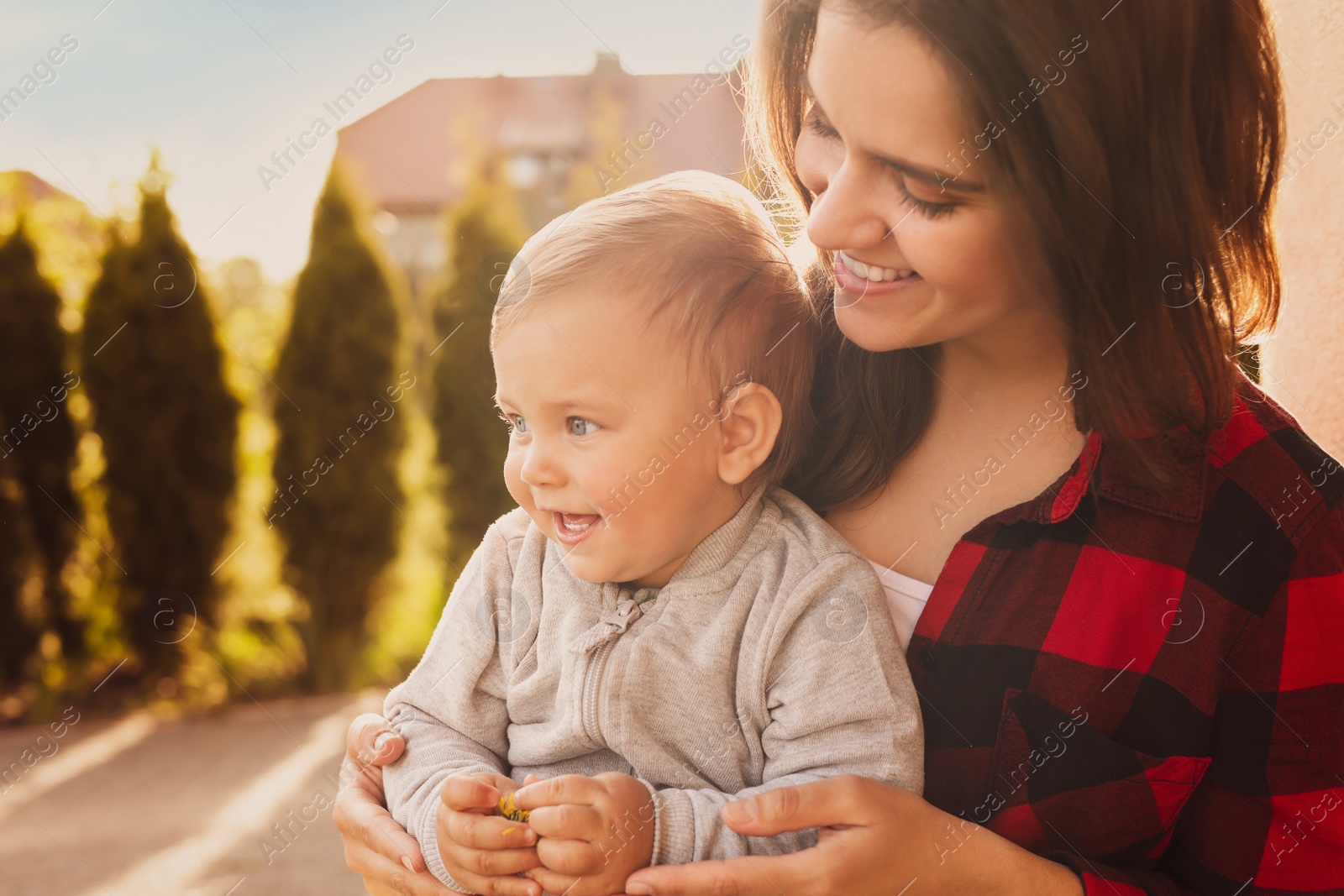 Image of Happy mother with her cute baby at backyard on sunny day