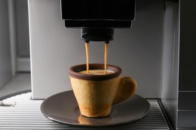 Coffee machine pouring espresso into edible biscuit cup