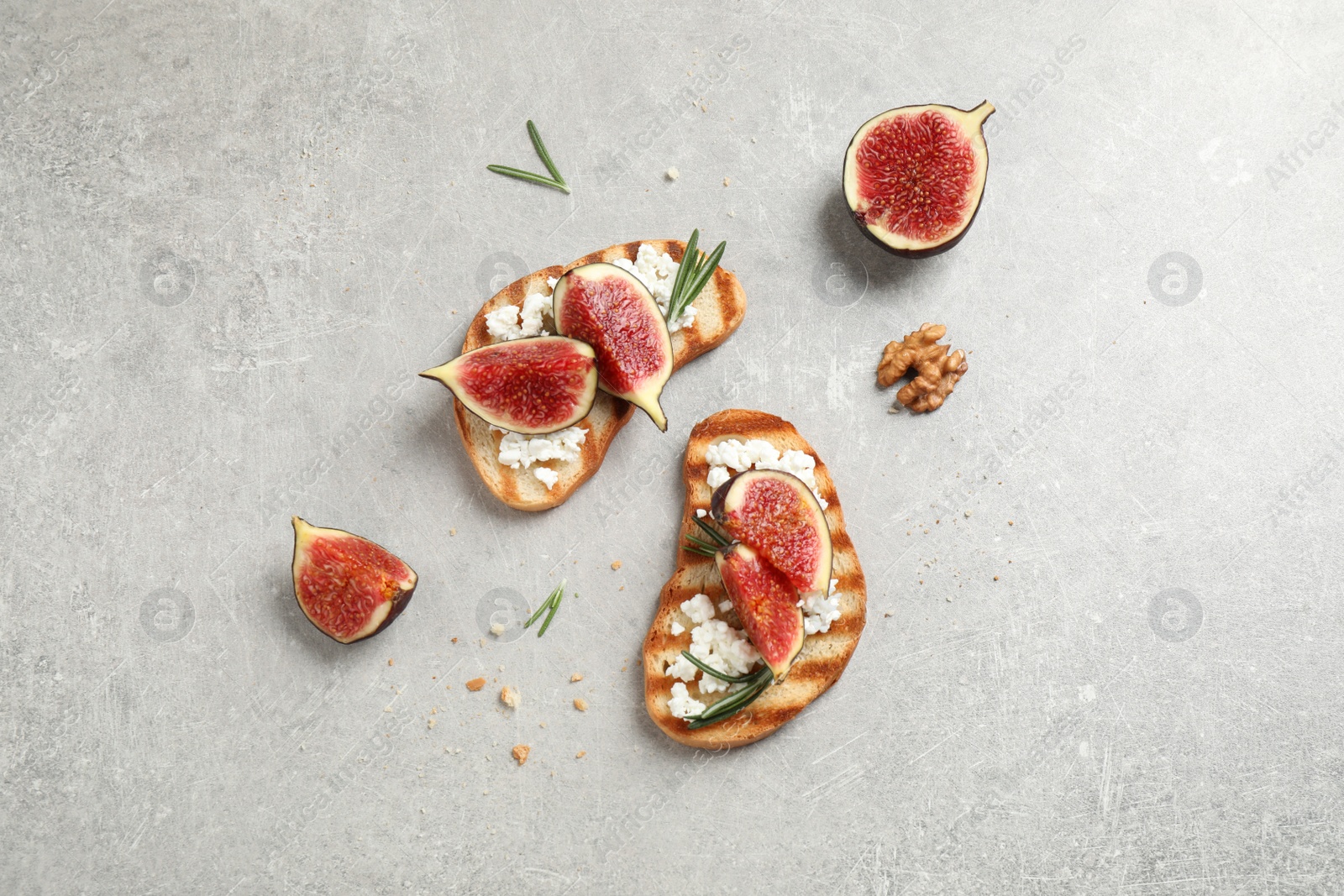 Photo of Bruschettas with ripe figs and cheese on light table, flat lay