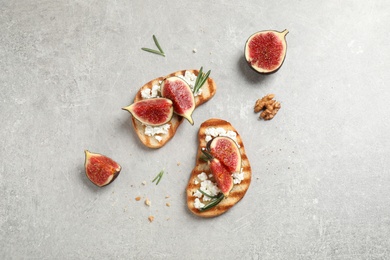 Bruschettas with ripe figs and cheese on light table, flat lay