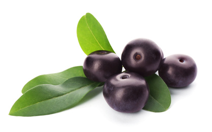 Pile of fresh acai berries with leaves isolated on white