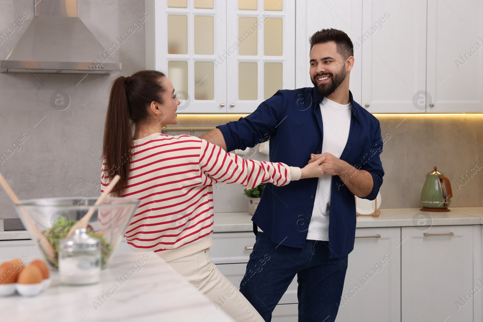 Photo of Happy lovely couple dancing together in kitchen