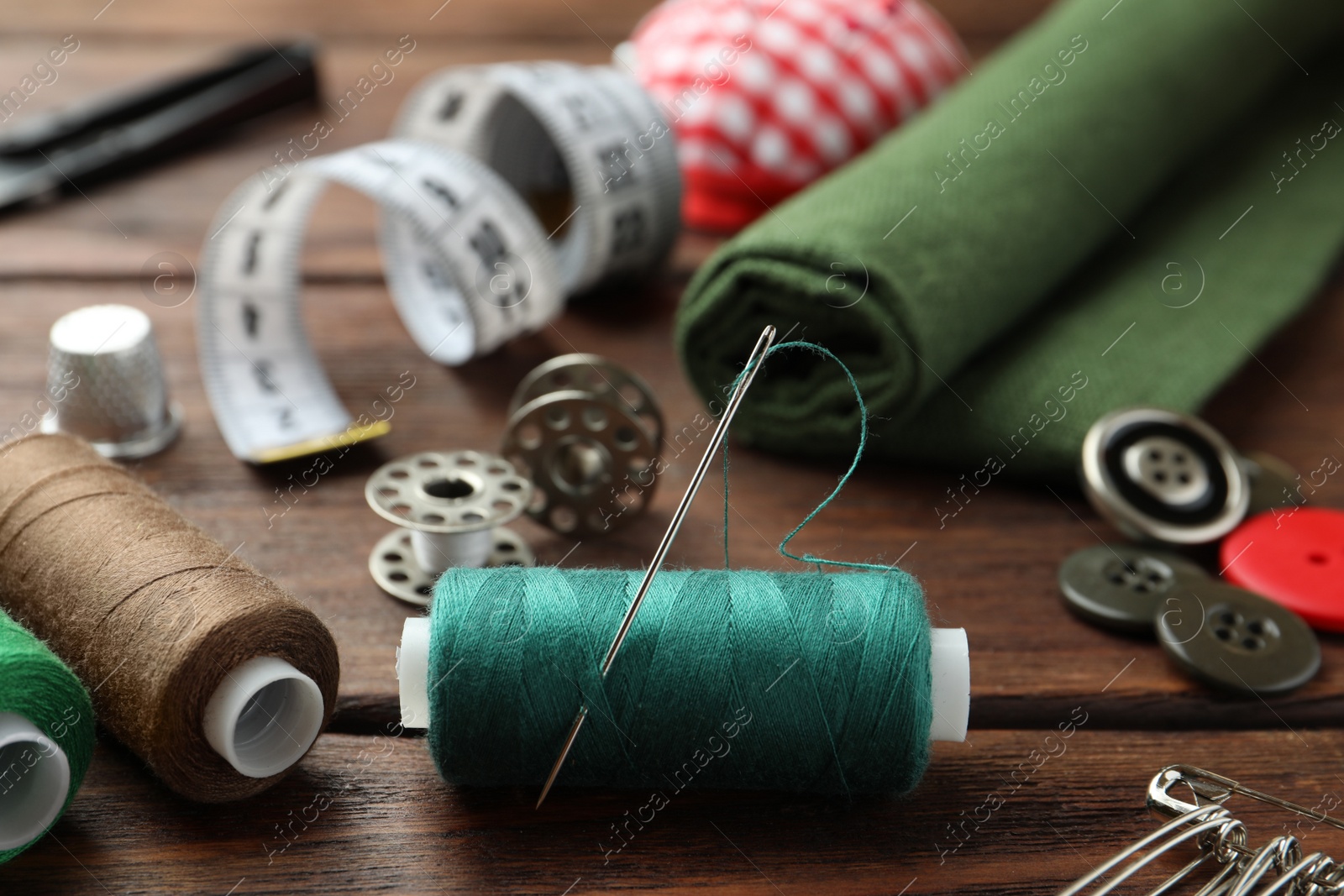 Photo of Threads and other sewing supplies on wooden table