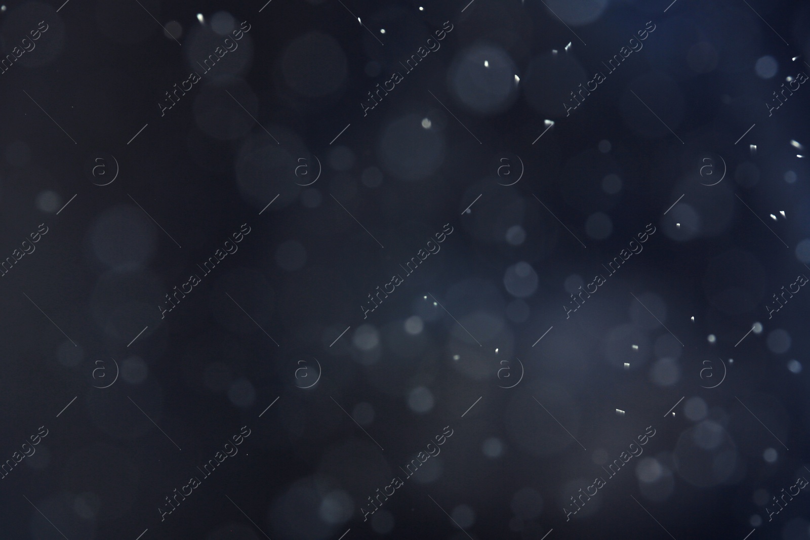 Photo of Silver glitter on dark background. Bokeh effect