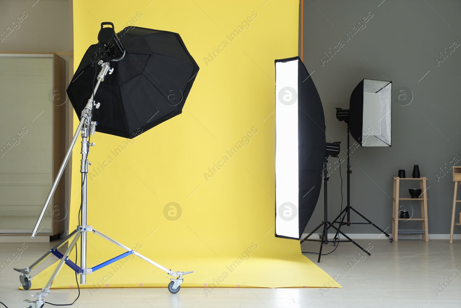 Photo of Yellow photo background and professional lighting equipment in modern studio