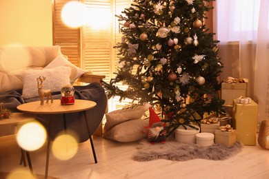 Beautiful Christmas tree and gift boxes in festively decorated room. Bokeh effect