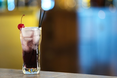 Photo of Fresh alcoholic cocktail with cherry on bar counter, space for text