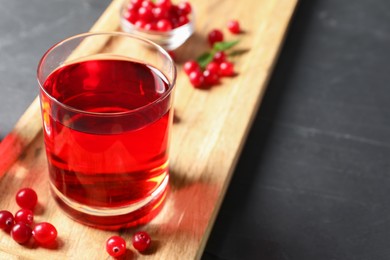 Photo of Tasty refreshing cranberry juice and fresh berries on grey textured table. Space for text