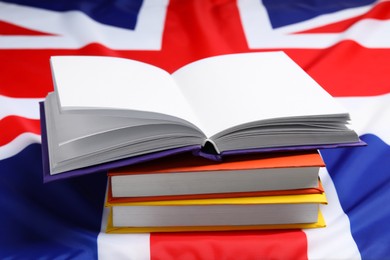 Photo of Learning foreign language. Different books on flag of United Kingdom