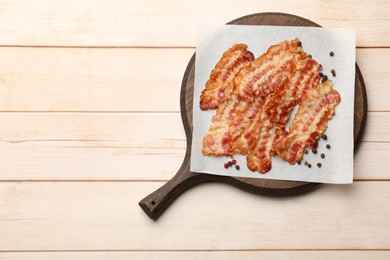 Photo of Delicious fried bacon slices on white wooden table, top view. Space for text