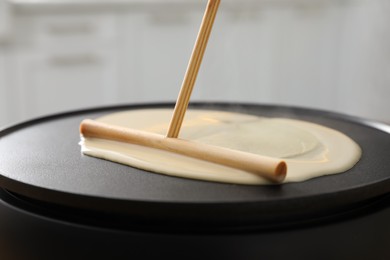 Photo of Cooking delicious crepe on electrical pancake maker, closeup