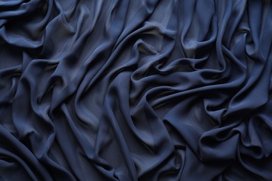 Photo of Beautiful dark blue tulle fabric as background, top view