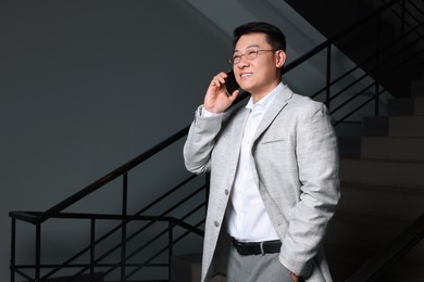 Photo of Happy boss talking on phone in office. Space for text