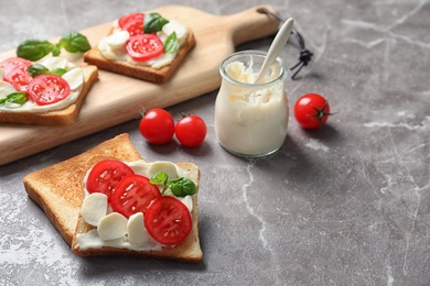Photo of Tasty toast bread with cream cheese and cherry tomatoes on color background
