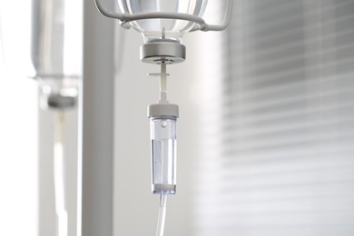 Photo of IV drip chamber against blurred light background