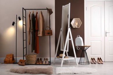 Photo of Modern dressing room interior with clothing rack and mirror