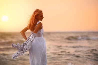 Photo of Beautiful young woman on beach at sunset