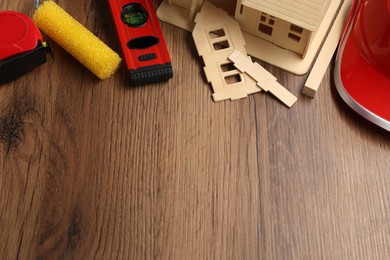 Photo of Building level and other construction tools on wooden table, above view. Space for text