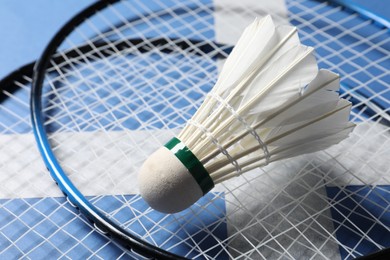 Photo of Feather badminton shuttlecock and rackets on blue background, closeup
