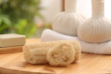 Photo of Loofah sponges on wooden table indoors, closeup