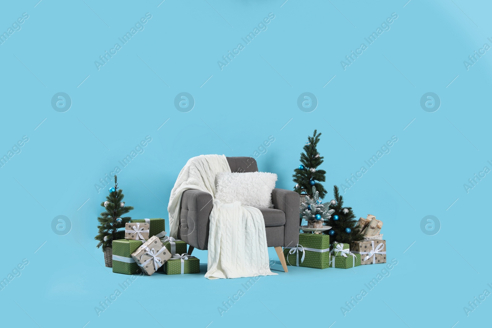 Beautiful Christmas themed photo zone with stylish armchair, trees and gift boxes in studio Photo of Beautiful Christmas themed photo zone with stylish armchair, trees and gift boxes in studio