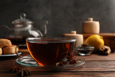 Photo of Aromatic tea with anise stars on wooden table