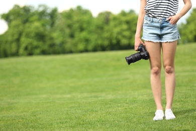 Photo of Photographer with professional camera in park. Space for text