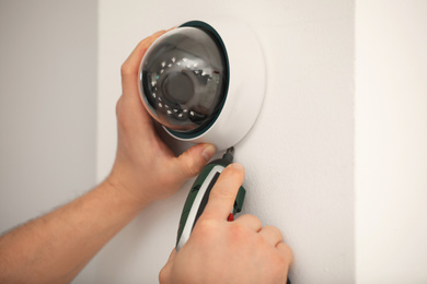 Photo of Technician installing CCTV camera on wall, closeup