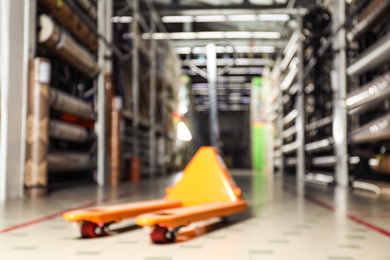 Photo of Blurred view of manual pallet truck in wholesale warehouse