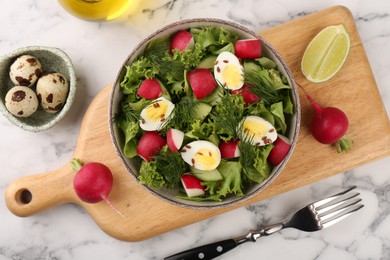 Delicious salad with radish, lettuce and boiled quail eggs served on white marble table, flat lay