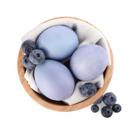 Photo of Colorful Easter eggs painted with natural dye and fresh blueberries on white background, top view