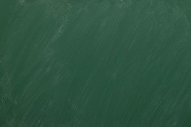 Photo of Dirty green chalkboard as background. School equipment