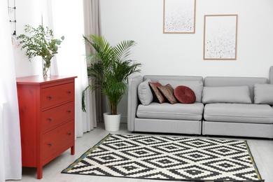 Photo of Living room interior with red wooden chest of drawers
