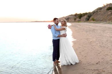 Photo of Wedding couple. Bride and groom standing on beach
