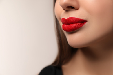 Photo of Beautiful woman with red lipstick on light background, closeup. Space for text