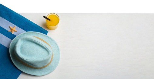 Photo of Towel, hat and drink on white wooden background, space for text. Beach accessories