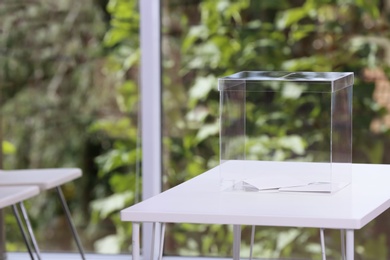 Photo of Ballot box on table at polling station. Space for text